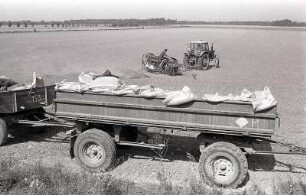 Drillen : Feldarbeit. Ein Traktor bearbeitet den Acker mit einer Egge