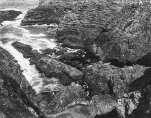 Bucht : Die Wellen brechen sich an den Felsen einer Bucht.