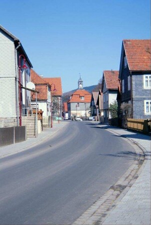 Straße mit Häusern, hinten alte Schule