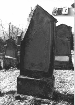 Grabstein 317 (Index: 99786310) Zustand: obere linke Ecke abgebrochen, Vorderseite vollständig Maße HxBxT: 156x57x24 cm Besonderheit: kulturhistorisch wertvoll / hist.-wiss. Gründe (Gemeindestellung): Grabstein 317