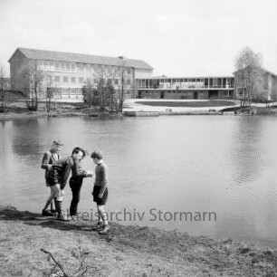 Realschule Harksheide: Fadens Tannen: Neubau vor Einweihung: davor Schulhof und Büsche: vorn Teich auf Schulgelände: rechts Gruppe Kinder