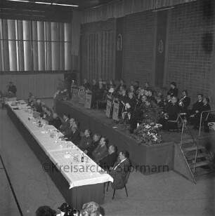 Bad Oldesloe: Stormarnhalle: Kreisfeuerwehrverband: Jahrestagung: Blick von der Empore auf Präsidiumtisch und Bühne mit Oldesloer Musikzug der Freiwilligen Feuerwehr Bad Oldesloe