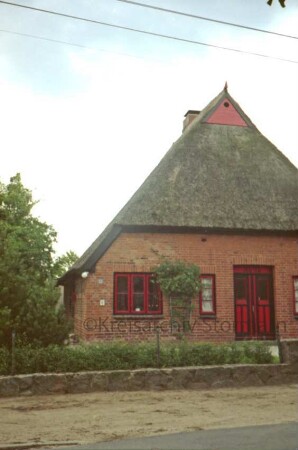 Dorfstraße 32: Backsteinkate mit Reetdach: Teilansicht: giebelständige Straßenfront: mit Eingangstür