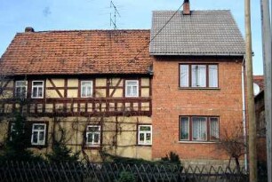 Haus mit Sichtfachwerk im OG, daran neuer Ziegelmauerwerkanbau
