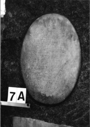 Grabstein 7 (Index: 100081786) Material: Granit, weiße Marmorplatten Zustand: Schriftplatten verwittert Maße HxBxT: 156x60x27 cm Beschreibung: konische Stele, gerader Abschluß, ovale und querrechteckige Schriftplatte: Grabstein 7A (2)