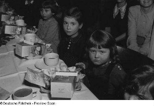 Kinder an einer Tafel sitzend