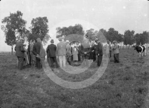 Reisegruppe auf einer Viehweide eines unbekannten Gutes