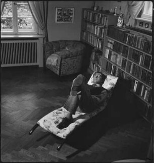 Portraitserie Walter Trier : Der Zeichner und Illustrator Walter Trier auf einer Liege in seinem Wohnzimmer