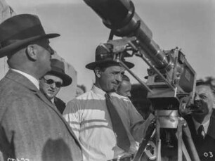 Filmkamera : Eine (Film-) Kamera mit ihrer großen Fernbildlinse wird von einigen Männer inspiziert.