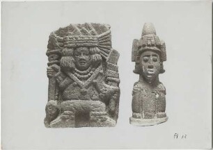 "Zwei Darstellungen (Tezontli) des Frühlingsgotes Xipe; die linke Figur in Tanzstellung (?) mit Tlachieloni (Sehinstrument) und reichem Schmuck, die rechte in Hockstellung mit der Charaktieristischen Xipe- Mütze. Höhe: 22 cm"