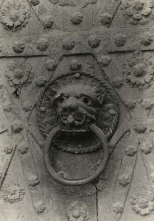 Türklopfer: Löwenkopf mit kleinem Menschen im Maul. 2. Hälfte 12. Jahrhundert. Bronzeguß, ziseliert; Durchmesser 26 cm. Erfurt, Dom, Nordostportal des Triangels