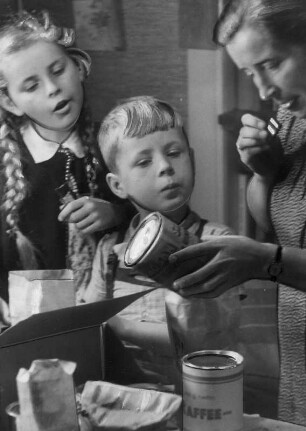 Ein Care Paket ist angekommen. Gemeinsam wird es ausgepackt. Aufgenommen 1947