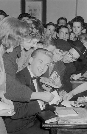 Der Sänger Francis Lorry beim Schreiben von Autogrammen