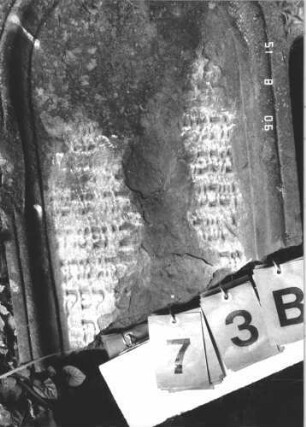 Grabstein 73 (Index: 100106511) Material: Sandstein Zustand: stark verwittert, weitgehender Textverlust, Stele zerbrochen Beschreibung: Stele mit Runbogenabschluß, Schriftfeld eingetieft, Sockel: Grabstein 73B