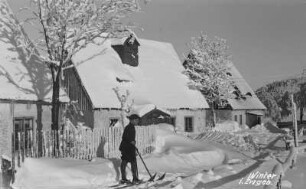 Winter im Erzgebirge : Erzgebirge. Altenberg. Verschneites Wohnhaus, im Vordergrund ein Kind auf Skiern. Winteraufnahme