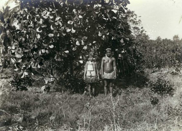 "Man and girl in front of a tree, Nauru"