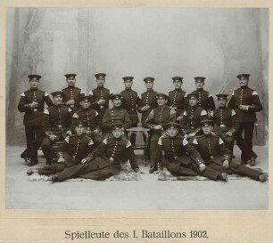 Spielleute des I. Bataillons des Regiments im Fotoatelier in drei Reihen vor Kulisse gruppiert