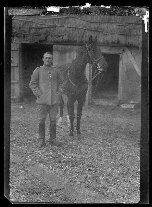 Oberleutnant Donle, Ortskommandant von Halles (Ortsteil von Péronne, Dep. Somme, Frankreich), mit Eisernem Kreuz neben einem Pferd