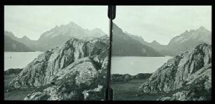 Norwegen: Fjordlandschaft. Felsgestein am Ufer eines Fjordes mit Blick auf weite Berglandschaft