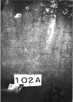 Grabstein 102 (Index: 100085536) Maße HxBxT: 158x70x20 cm Beschreibung: profil. Sockel, giebelart. Abschl. m. Verdach. , Schrift eingetieft m. Spitzbogenabschl. Symbolik: Maßwerk: Grabstein 102A