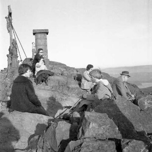 Hofbieber-Danzwiesen. Milseburg (835,2 m NN). Rast einer Wandergruppe auf dem Gipfel. Blick gegen Kreuzigungsgruppe (Seitenansicht)