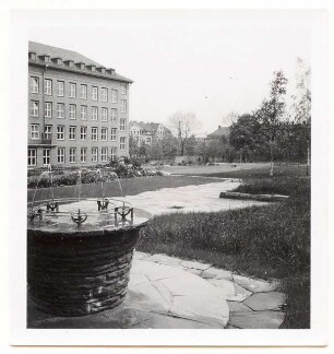 Grünflächen am Verwaltungsgebäude der Böhme Fettchemie, Chemnitz: Gebäude mit Trinkbrunnen und Plattenverlegung