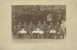 17 Offiziere in Uniform mit Mütze beim Punsch trinken, stehend oder an gedeckten Tischen in Garten sitzend