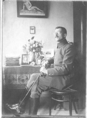 Hans Richter in Uniform, an einem Tisch sitzend