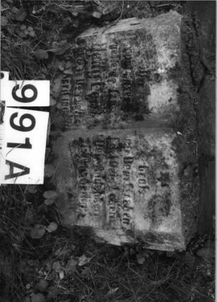 Grabstein 991 (Index: 99630494) Material: Sandstein Zustand: stark abgeblättert-Stele Maße HxBxT: 108x48x6 cm Beschreibung: Stele mit eingezogenem Rundbogenabschluß Besonderheit: Zitat Psalm 116, 9: Grabstein 991A