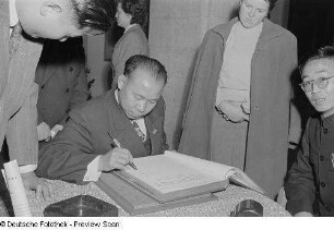 Chinesischer Delegierter beim Eintrag in das Gästebuch im Georgi-Dimitroff-Museum (heutiges Bundesverwaltungsgericht)
