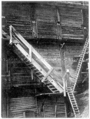 Ein Arbeiter steigt Holztreppen hinunter