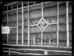Unbekannte Ortschaft [Litauen/Weißrussland/Ukraine?]: Innenwand einer Holzhütte, ausgeschmückt mit Birkenholz und dem Foto eines (hohen?) Offiziers