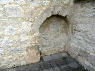 Haueda-(Evangelische Kirche) - Kirchturm im Süden-Erdgeschoß-alter Eingang (rundbogig gewändet) mit Wetzrillen im Werkstein (Symbolische Entschärfung der Dolche) in Übersicht