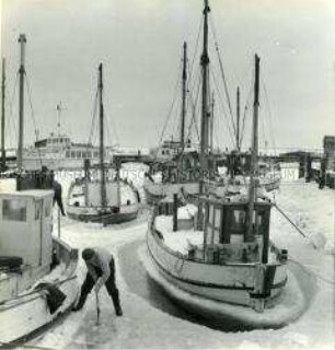 Eingefrorene Boote im Fischerhafen Vitte auf der Insel Hiddensee werden freigeschaufelt