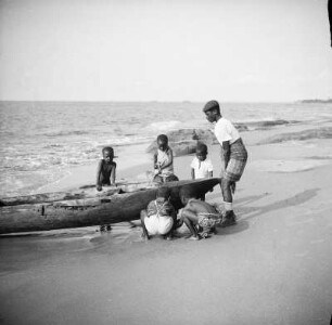 Kinder am Strand : Kinder ziehen ein Fischerboot an Land.