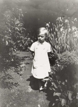Kleines Mädchen in einem Garten stehend