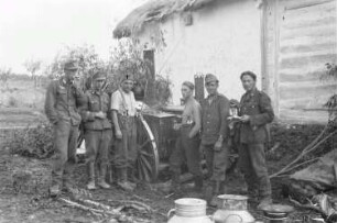 Zweiter Weltkrieg. Frontbilder. Rußland, Oblast Belgorod. Angehörige der deutschen Wehrmacht bei einer Goulaschkanone vor einem Bauernhaus (vielleicht in Lutschki)
