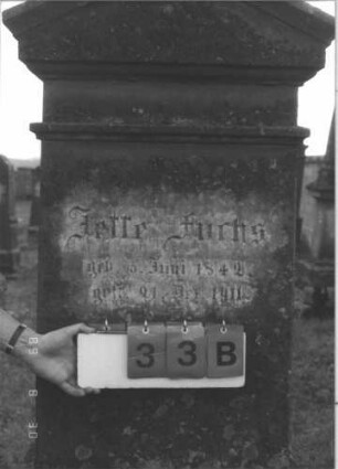 Grabstein 33 (Index: 99609669) Material: Sandstein Zustand: stark verwittert, versalzen Maße HxBxT: 189x65x30 cm Beschreibung: Stele, Giebelabschluß mit Verdachung, Mittelpalmette, Schriftfeld rechteckig eingetieft, getreppter Sockel, unten Rusticaimitat: Grabstein 33B
