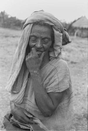 Portrait einer Frau der Arsi-Oromo : Portrait einer alten Frau der Arsi-Oromo mit geschloßenen Augen vor Hütten auf einem Hochplateau (2600m)