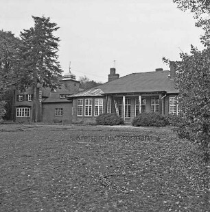 Am Bondenholz: Lunugala [ehemaliger Jugendhof]: Blick vom Park auf Gebäudeensemble: vorn Gruünfläche: hinten auf Veranda Leiter: links Fahnenmast: hinten rechts und links Bäume