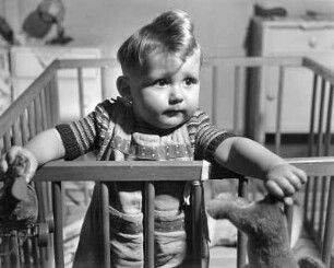 Kinderbilder. Kleinkind im Laufgitter