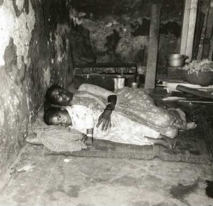 Indien. Wohnung einer indischen Familie in Madras, Mutter und Kind ruhend auf einer Matte