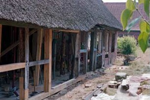 Reinbeker Straße 4a: giebelständige Fachwerkkate mit Reetdach: Restaurierung: Traufseite, Teilansicht: von vorne nach hinten Wirtschaftstrakt, Sprung, Wohntrakt: Austausch von Schwellbalken, Ständer, Riegel: Blick durch offene Gefache in Hausinneres: Baumaterialien, Werkzeug, Schubkarre: im Hintergrund rechts Haus