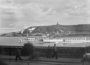 Rochuskapelle bei Bingen am Rhein, davor der Ausflugsdampfer Mainz und Passanten an der Rheinpromenade