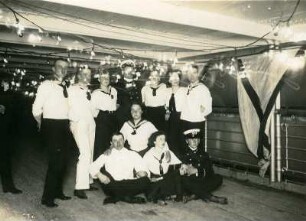 Gruppenbildnis mit maritim kostümierten Touristen an Deck eines Hochseepassagierdampfers ("Cleveland"?)