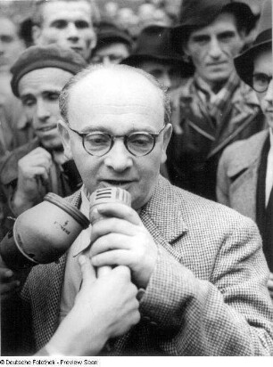 Gerhart Eisler mit Mikrofon während seines Empfangs in der Stadt