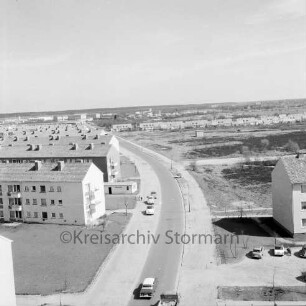 Stonsdorfer Weg: Straße mit Wohngebäude, dahinter rechts Wohngebäude des Tucheler Weges, im Hintergrund das Gewerbegebiet Stonsdorf: Blick vom Rathausgebäude Richtung Osten