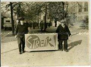 Streikende Metallarbeiter mit Plakat