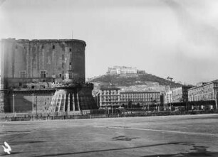 Fort : Große Häuser neben einem Fort, im Hintergrund Hügel mit Villa