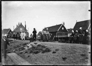Niederlande, Marken. Deich mit Passanten und Wohnhäusern